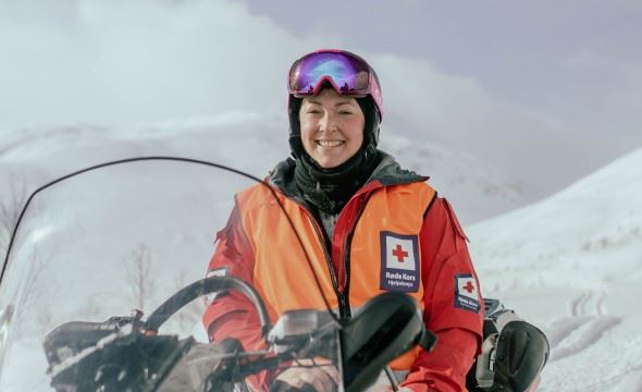 EN kvinne fra hjelpekorpset står i en snøhaug